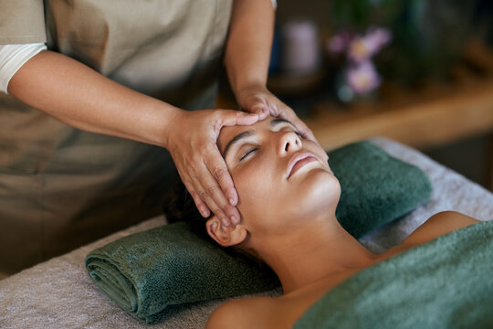 Relaxed woman getting head massage at spa