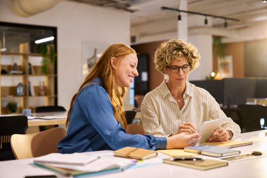 Busineswomen working together on digital tablet at board room