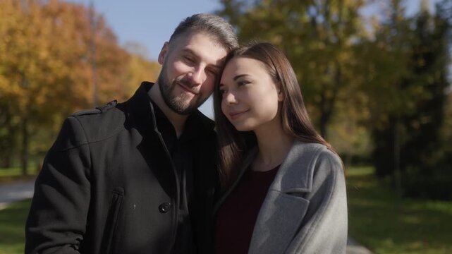 Portrait of one young romantic couple in an autumn park in a cinematic lifestyle.