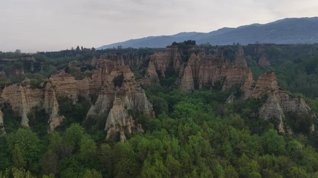 Aerial view of the Balze geological formations with clay towers and erosion surrounded by lush green forests and hills in Reggello, Tuscany, Italy.