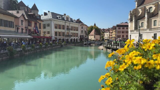 Broad canal view in Annecy, France, conveying tranquil urban waterside life, historic architecture, and refined European travel charm.