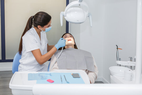 Dentist conducts examination of patient in modern dental clinic with tools and protective equipment