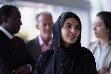 Obraz premium Business team discussion with professional woman in hijab leading conversation in diverse office setting