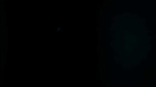 Man walking away into the darkness of a gloomy corridor. Eerie mystery in a horror atmosphere. Scary suspense scene of a male figure vanishing in deep shadow.