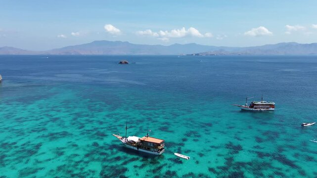 A tourist yacht off the coast of Padar Island, Komodo National Park. Tourists return to the yacht after relaxing on Pink Beach