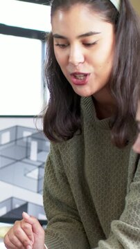 Vertical video: Architect noticing 3D plan on monitor, leaning and pointing while explaining layout