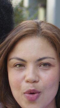 Vertical video: Mouthing duet, second entering from right, women in garden, pink top and nose ring