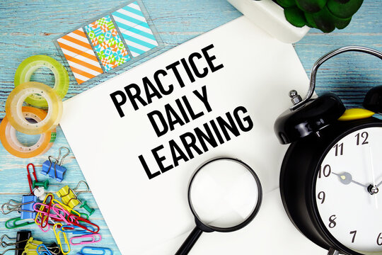 Practice Daily Learning text on a paper surrounded by office supplies, a magnifying glass, and a clock on a blue wooden surface
