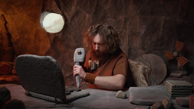 Confused caveman trying to repair a broken stone laptop with a hammer