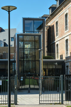 Modern glass facade of Universit&eacute; Polytechnique Hauts de France in Valenciennes reflecting light and contemporary architecture.