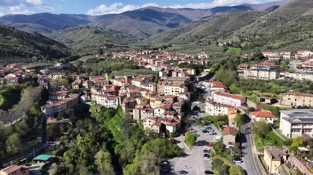 Aerial view of the historic town of Loro Ciuffenna with its terracotta rooftops nestled among the lush green hills and mountains, Reggello, Tuscany, Italy.