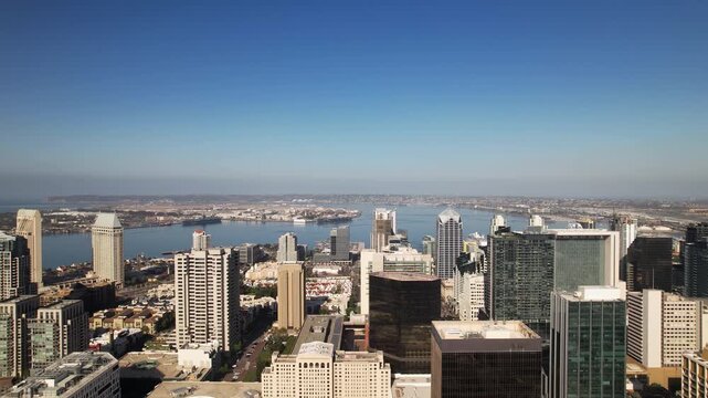 Drone flying sideways south above 5th Street in downtown San Diego at 9AM with camera facing west across the city.