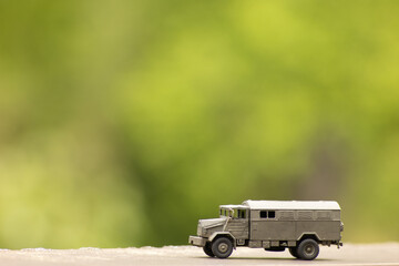 Fototapeta premium Miniature Military Transport Truck – Toy Army Vehicle in Natural Outdoor Setting