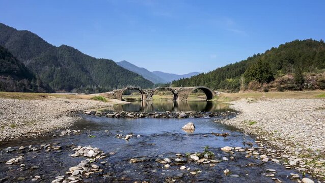 Time-lapse of the historic three-arch stone bridge over a flowing stream in Wuyuan County, Jiangxi Province, China.