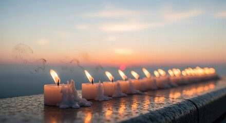 Row of lit candles at sunrise for Anzac Day remembrance ceremony