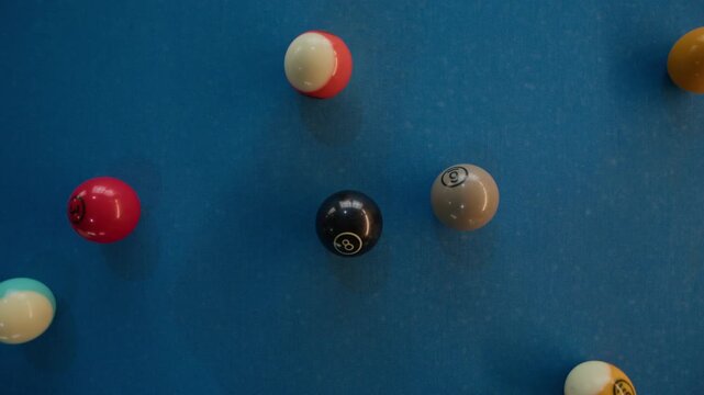 Close up shot of cue ball hitting tightly racked colorful billiard balls in triangle formation on blue pool table
