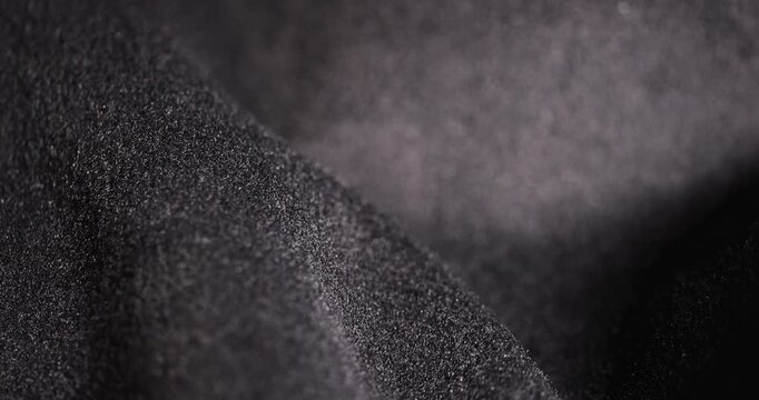 warm Fabric forms curves, dark fleecy fabric with a velvety surface and fine fibers under soft light with an authentic look and organic structure in the macro.