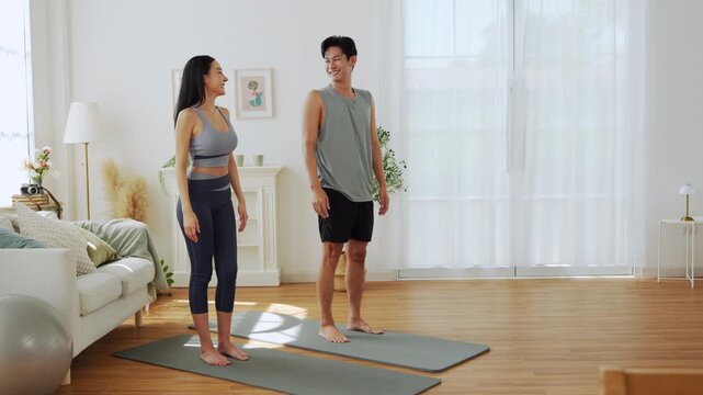 Asian couple giving high five during home workout and yoga