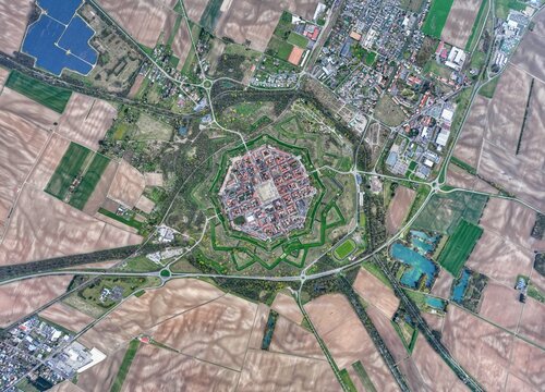 Aerial view of the star-shaped fortress city with its intricate bastions and geometric streets amidst the patchwork fields, Neuf-Brisach, Grand Est, France.