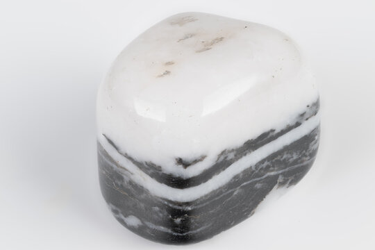 Closeup of patterned mineral. Polished siliceous argillite displaying banding and gloss. Closeup of polished striped rock showing mineral layers and reflective surface