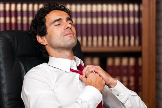 Exhausted businessman relaxing in office