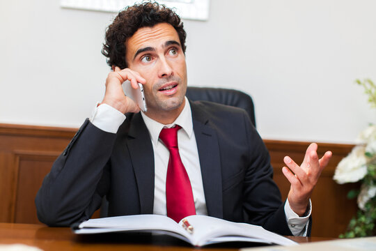 Businessman in conversation on phone at desk