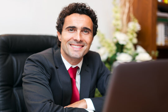Smiling businessman working on laptop