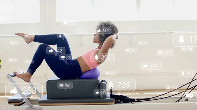 Vertical video: Woman doing reformer crunch in fitness studio each rep adding likes and toning core