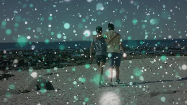 Vertical video: Two men walking toward water after step, keeping arm contact, teal dots drifting