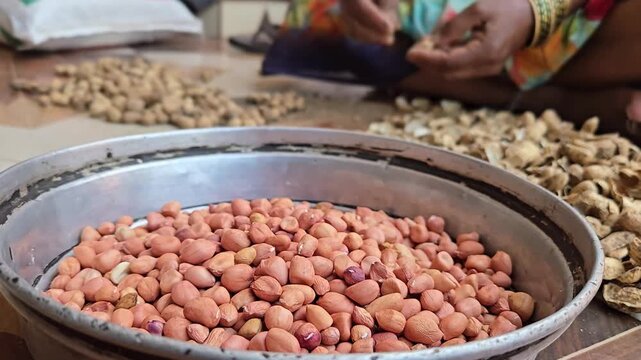 Unshelling peanuts involves cracking the hard outer pod to release the edible kernels inside. This can be done manually by hand, collecting the raw nuts in a bowl while discarding the empty shells nea