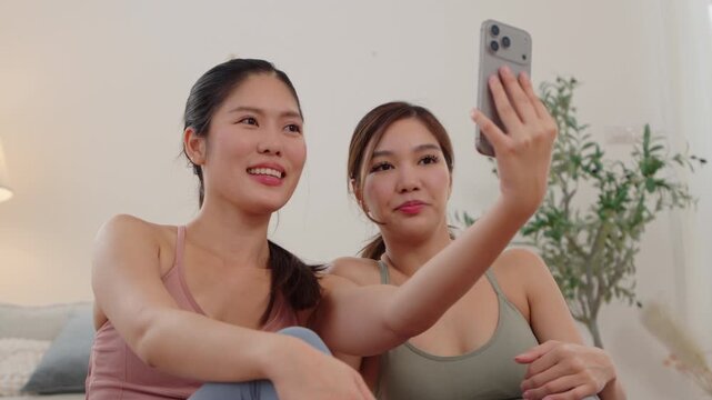 Two Asian women taking a selfie together after yoga at home