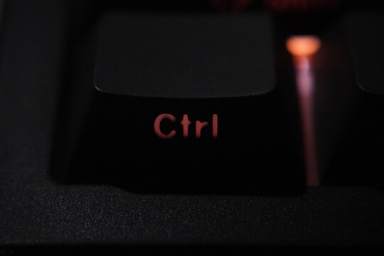 Close up of control key with red led light on black keyboard.