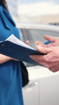Close-up of customer signing car repair agreement