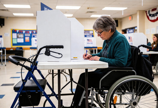 Senior woman in wheelchair filling out ballot at accessible voting booth in polling station, disability inclusion and civic participation for election day