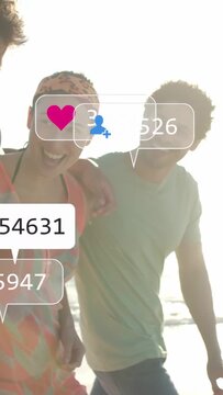 Vertical video: Group walking on beach cam opening sparking social icons over them showing reach