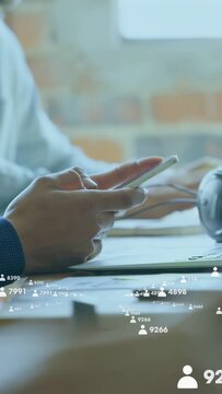 Vertical video: Hands tapping phone at desk causing animated counters increasing to track marketing