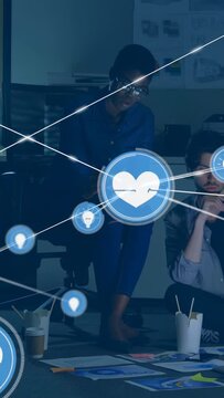 Vertical video: Blue heart appearing woman dark-shirt pointing man reading docs in office, overlay