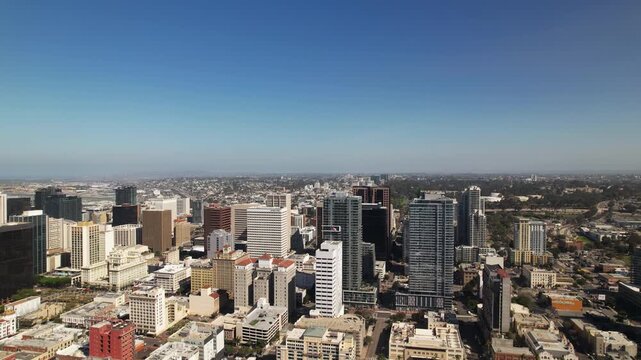 Wide aerial drone shot flying northwest above downtown San Diego at 9AM capturing the full city skyline and buildings.