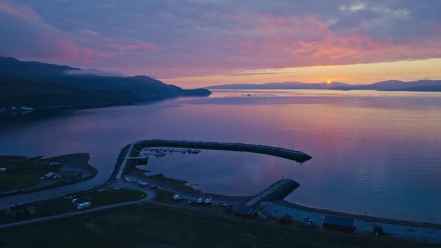 Kokelv, Hammerfest, Finnmark, Norway - The Sun Sets Over a Peaceful Bay, Casting a Soft Pink and Purple Glow Over the Water - Aerial Pullback Shot