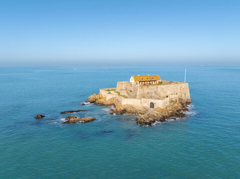 Aerial view of Fort National stands defiant against the turquoise sea, a stone sentinel under a clear sky, Saint-Malo, Brittany, France.