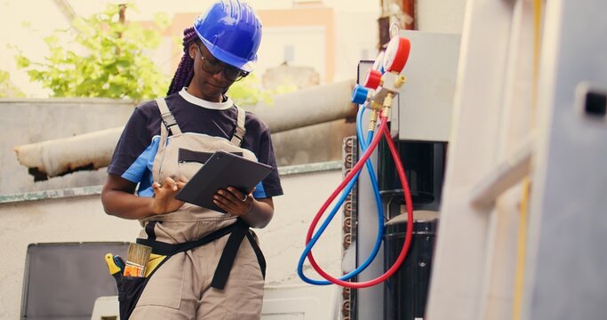 Knowledgeable professional calibrating ac gauges vacuum pump during comissioned condenser maintenance. Capable specialist looking for potential low pressure in air conditioner cooling system