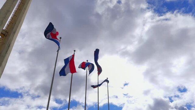 Paraguay flag waving against a cloudy sky in Plaza de Armas, Encarnacion, Paraguay
