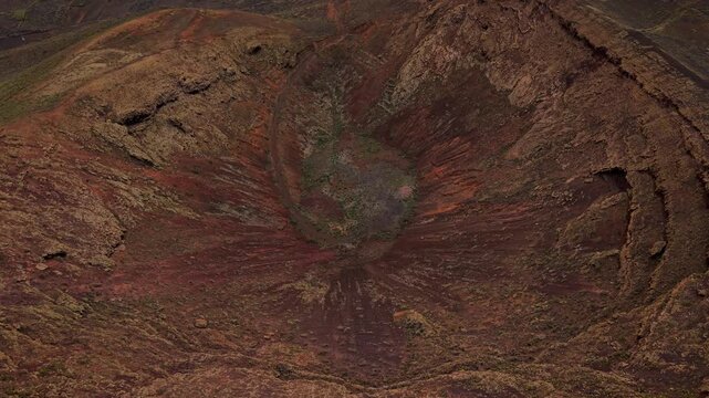 Lanzarote's Mirador del Gayo volcano caldera shows dramatic geological formations. Aerial, Pullback Shot