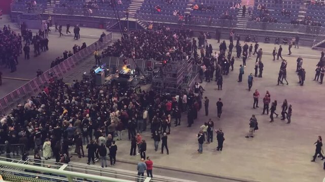 A vast crowd of people assembling within an indoor arena, filling both the floor and tiered seating, generating excitement for a major live entertainment event