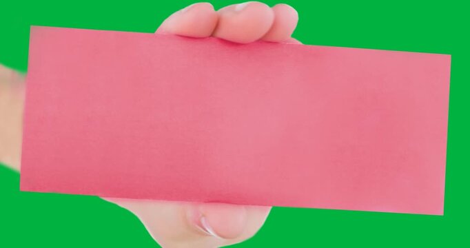 Hand holding a blank pink placard ith with copy space against black background