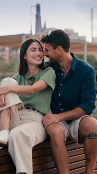 Video of beautiful couple posing and looking at camera while sitting on a bench in the city