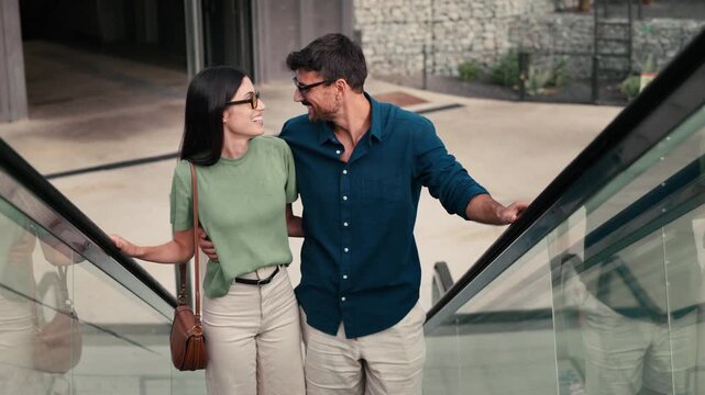 Video of loving couple talking and having fun while riding up an escalator in the city