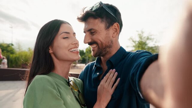 Video of beautiful couple taking photos of themselves with smartphone in the city