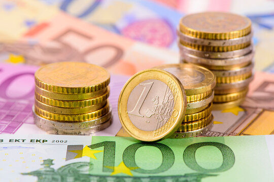 Viele Euro Banknoten und M&uuml;nzen liegen auf einem Haufen zusammen
