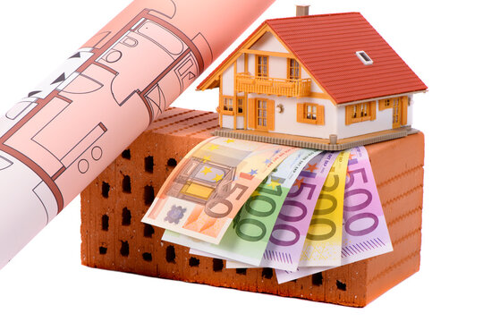 Symbolbild f&uuml;r Wohnungsbau mit Ziegelstein und Werkzeug